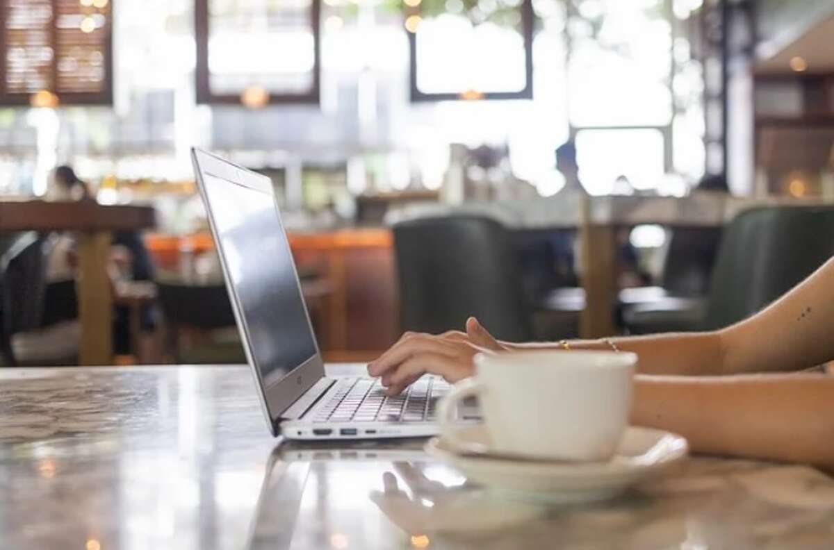 Blick auf einen Tisch im Café mit einer chattenden Person mit einem Kaffee